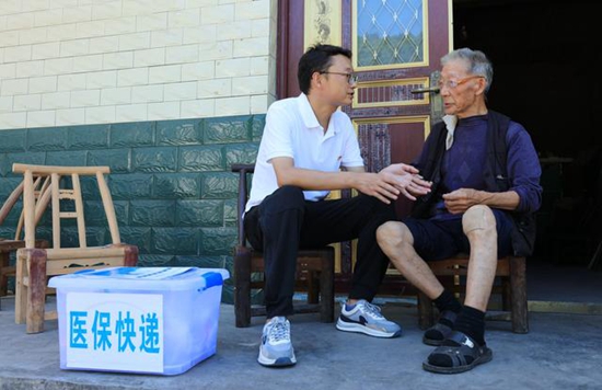 彭涛在村民家中了解和收集医保信息与诉求（图片来源新华社）。.jpeg