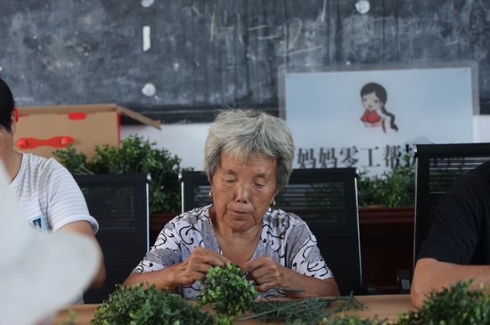 妈妈零工帮扶车间里正在忙着加工塑料手工品的“留守妇女”.jpg