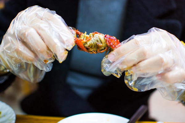 一个戴着塑料手套吃小龙虾的女人.jpg