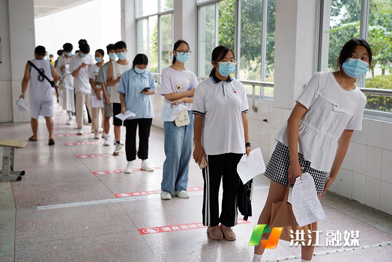 学生在校园走廊有序排队等候打疫苗。