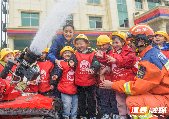 ​3月4日，道县消防救援大队特别邀请幼儿园的小朋友们走进营区，开展别开生面的“开学第一课”安全教育主题活动。活动现场，孩子们在消防救援人员的悉心指导下，亲身体验了消防水枪的操作。除了消防水枪体验，消防员们还向小朋友们生动讲解了消防安全知识，并展示了绳索攀爬等专业技能。这次沉浸式体验活动通过直观、互动的方式，让小朋友们在欢乐的氛围中学习消防安全知识，增强了他们的安全意识和应急避险能力，为新学期筑牢安全第一道防线。