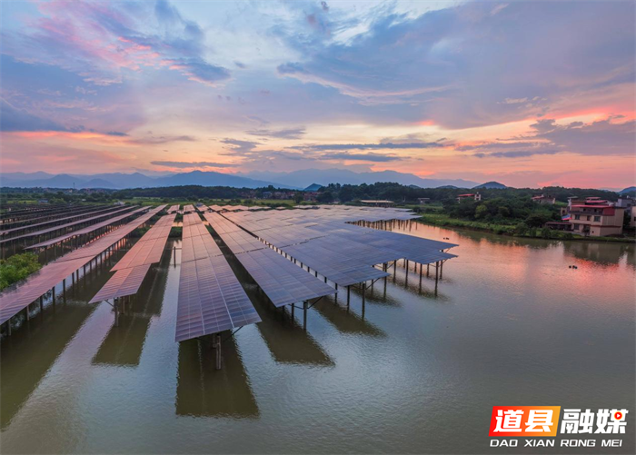 2026年7月13日，湖南省永州市道县祥霖铺镇胡家村，晚霞下的光伏电板与村庄、远山交相辉映，绘就秀美生态画卷。近年来，道县深挖水库空间优势，在水上布设光伏发电设备，水下发展特色水产养殖，大力推行渔光互补发展模式，拓宽群众增收致富路径。蒋克青摄
