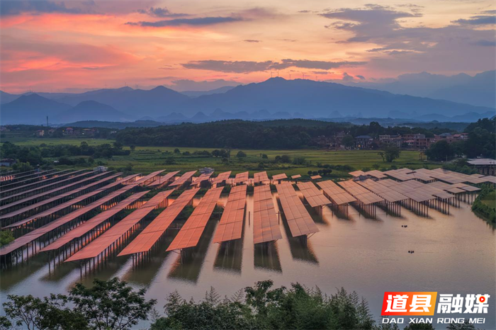 2026年7月13日，湖南省永州市道县祥霖铺镇胡家村，晚霞下的光伏电板与村庄、远山交相辉映，绘就秀美生态画卷。近年来，道县深挖水库空间优势，在水上布设光伏发电设备，水下发展特色水产养殖，大力推行渔光互补发展模式，拓宽群众增收致富路径。蒋克青摄