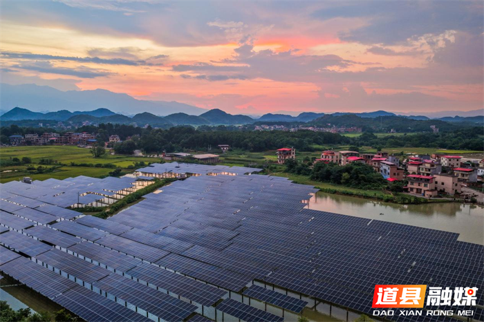 2026年7月13日，湖南省永州市道县祥霖铺镇胡家村，晚霞下的光伏电板与村庄、远山交相辉映，绘就秀美生态画卷。近年来，道县深挖水库空间优势，在水上布设光伏发电设备，水下发展特色水产养殖，大力推行渔光互补发展模式，拓宽群众增收致富路径。蒋克青摄