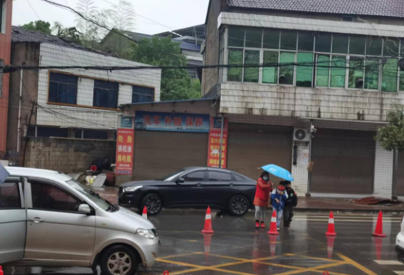 桃江县灰山港镇完全小学：教师雨中护苗雨 为孩子们撑起