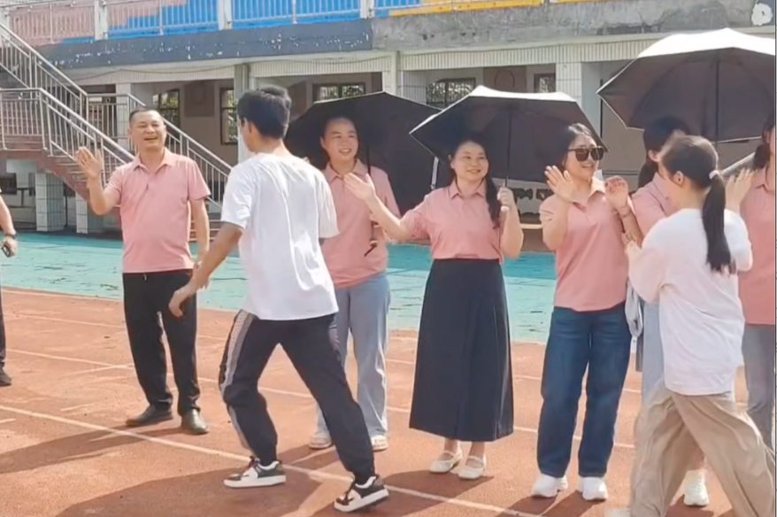 掌心跳动着祝福，声声击掌传递力量。汨罗三中送考现场，师生夹道相送。最动人的一幕：一位同学背着脚受伤的伙伴，稳稳奔向老师，三人击掌，同心同行。这份情谊，比分数更珍贵；这份团结，已是高考最美的答案。
