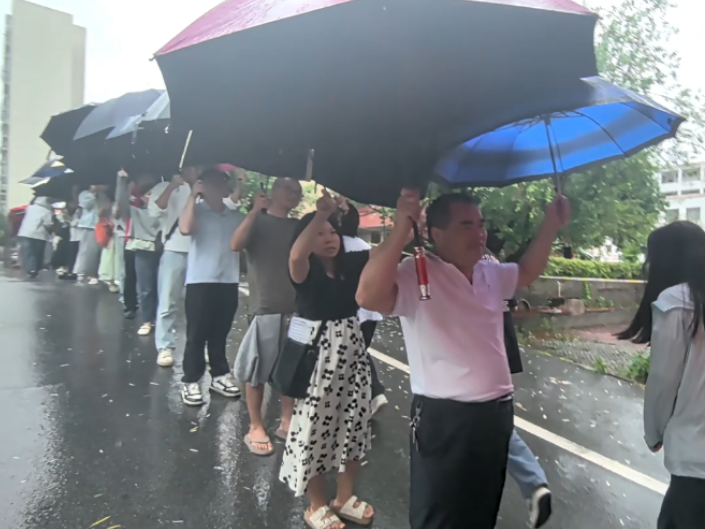 大雨天气暖心相伴，教师撑伞护航！高考次日，大雨倾盆。江华一中校园里，高三老师们自发撑伞列队，筑起一道暖心的避雨通道。风雨挡不住温情，一把把雨伞，为莘莘学子撑起一片逐梦晴空。