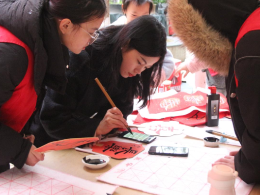 “六爱”教育进社区！长沙商贸旅游职院“红e青年”挥毫送暖