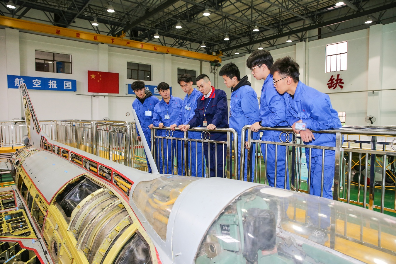 配图 飞机维修实训车间内，文韬（中）带领学生开展航空维修实训教学.png