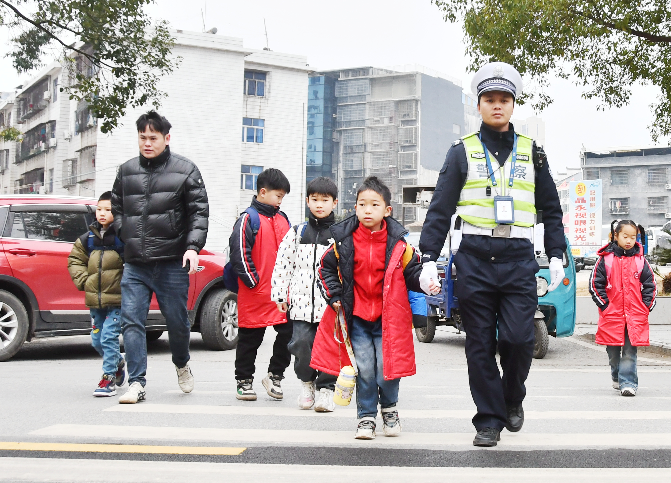 2月14日，湖南省永州市江永县实验小学校门口，交警护送学生过马路。田如瑞 摄.JPG