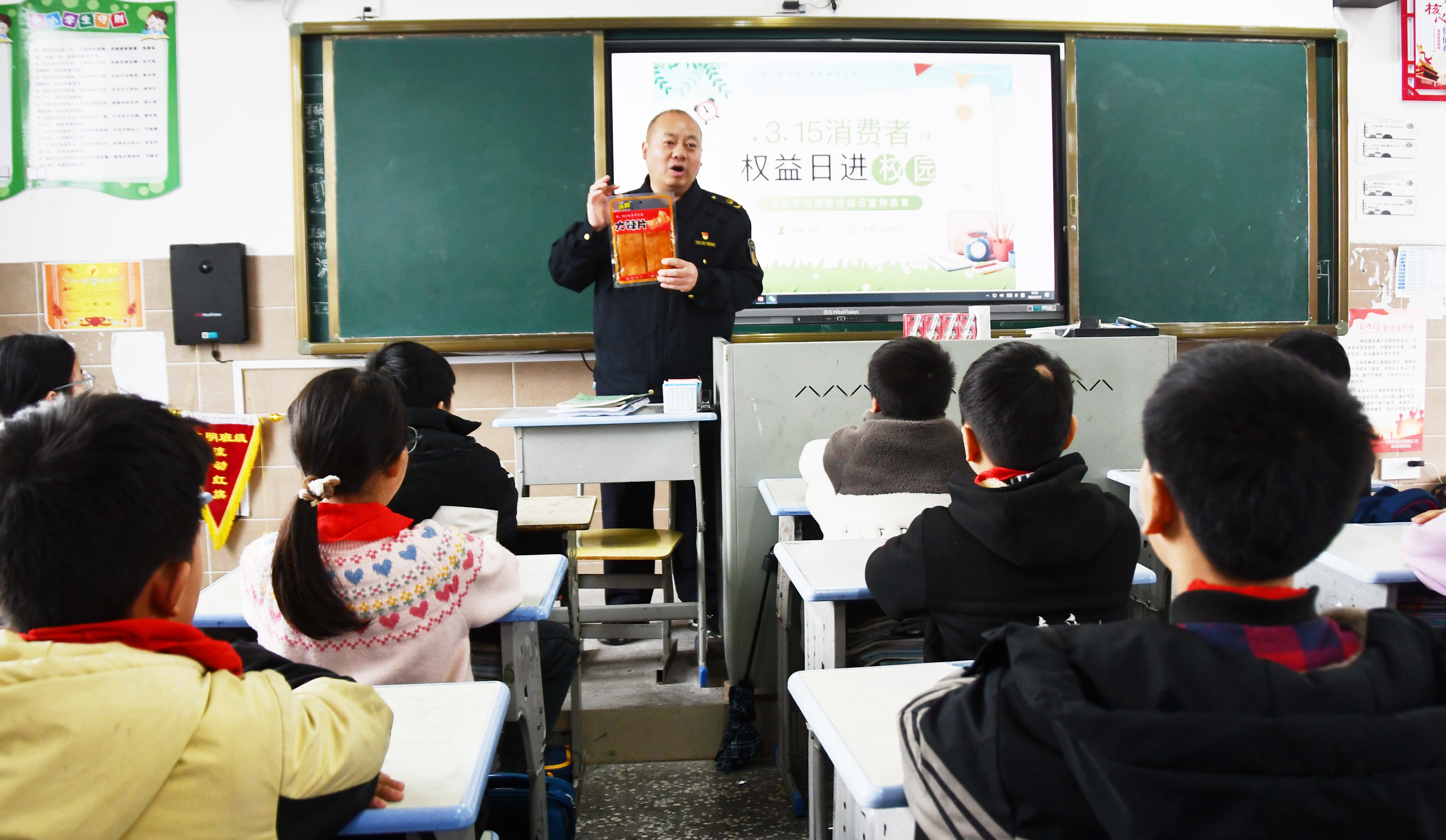 3月14日，在湖南省永州市江永县上江圩镇中心小学，市场监督管理人员正在向学生宣传食品保质期的认识方法。田如瑞摄 (6).JPG