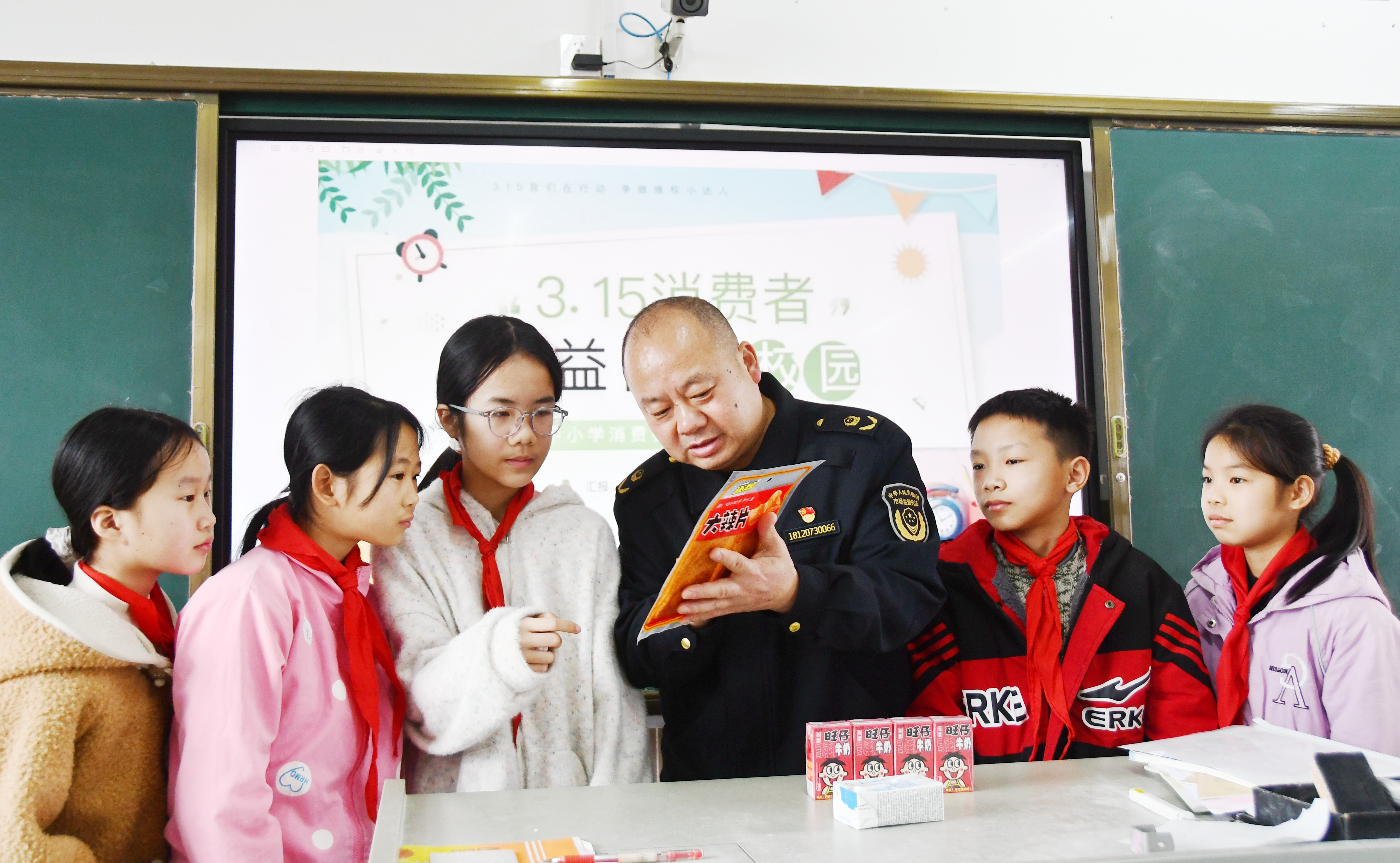 3月14日，在湖南省永州市江永县上江圩镇中心小学，市场监督管理人员正在向学生宣传食品保质期的认识方法。田如瑞摄 (3).JPG