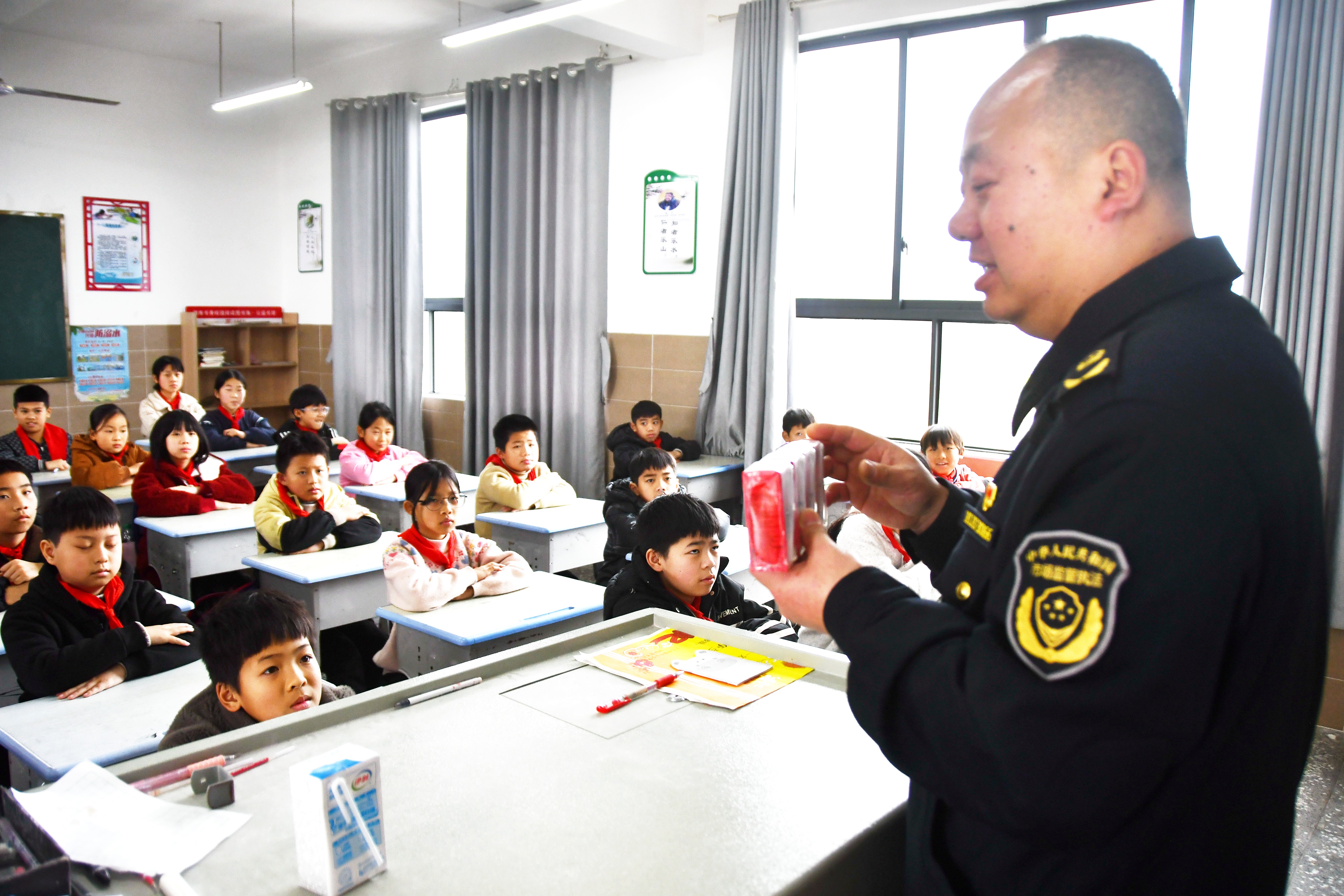 3月14日，在湖南省永州市江永县上江圩镇中心小学，市场监督管理人员正在向学生宣传食品保质期的认识方法。田如瑞摄 (9).JPG