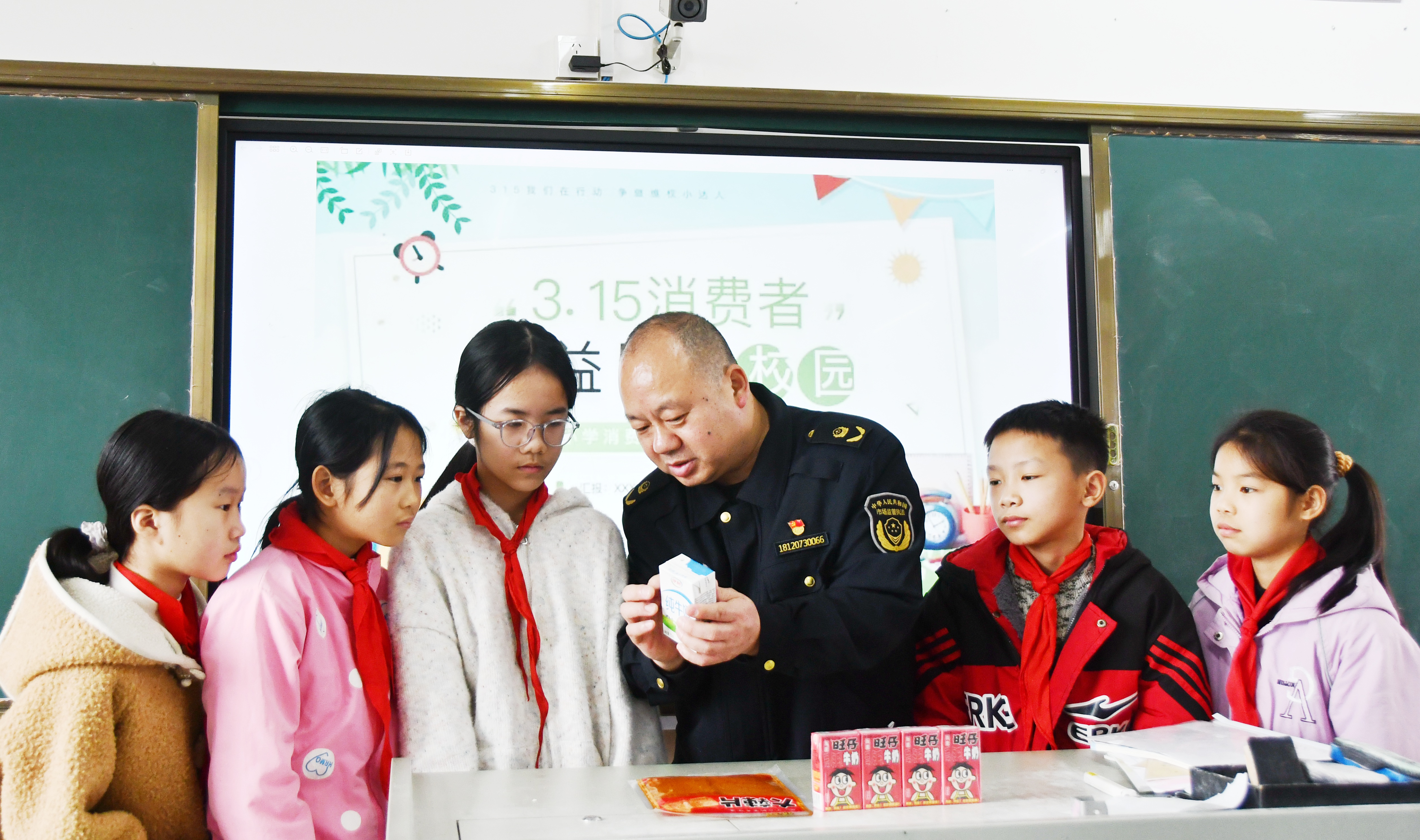 3月14日，在湖南省永州市江永县上江圩镇中心小学，市场监督管理人员正在向学生宣传食品保质期的认识方法。田如瑞摄 (4).JPG