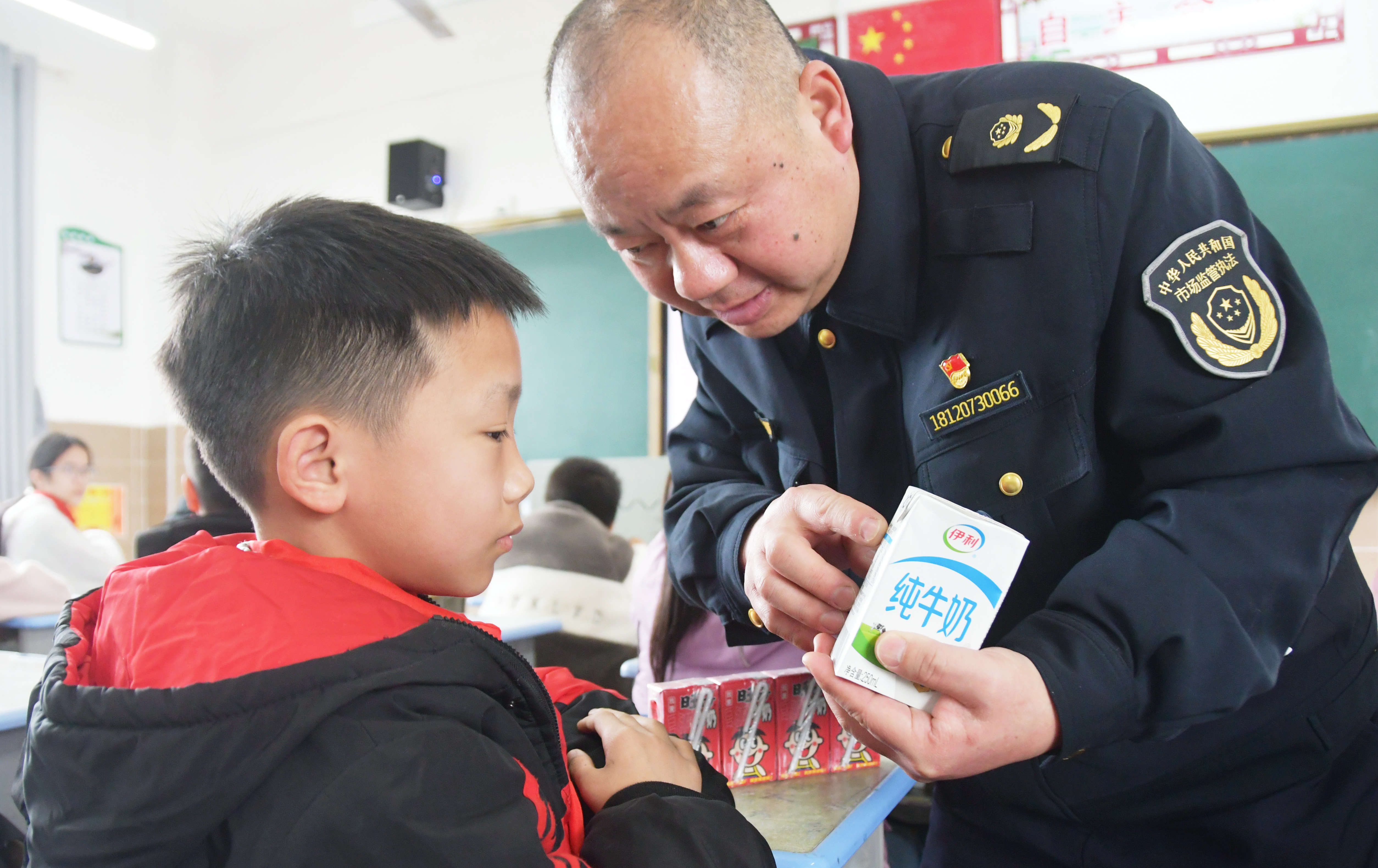 3月14日，在湖南省永州市江永县上江圩镇中心小学，市场监督管理人员正在向学生宣传食品保质期的认识方法。田如瑞摄 (1).JPG