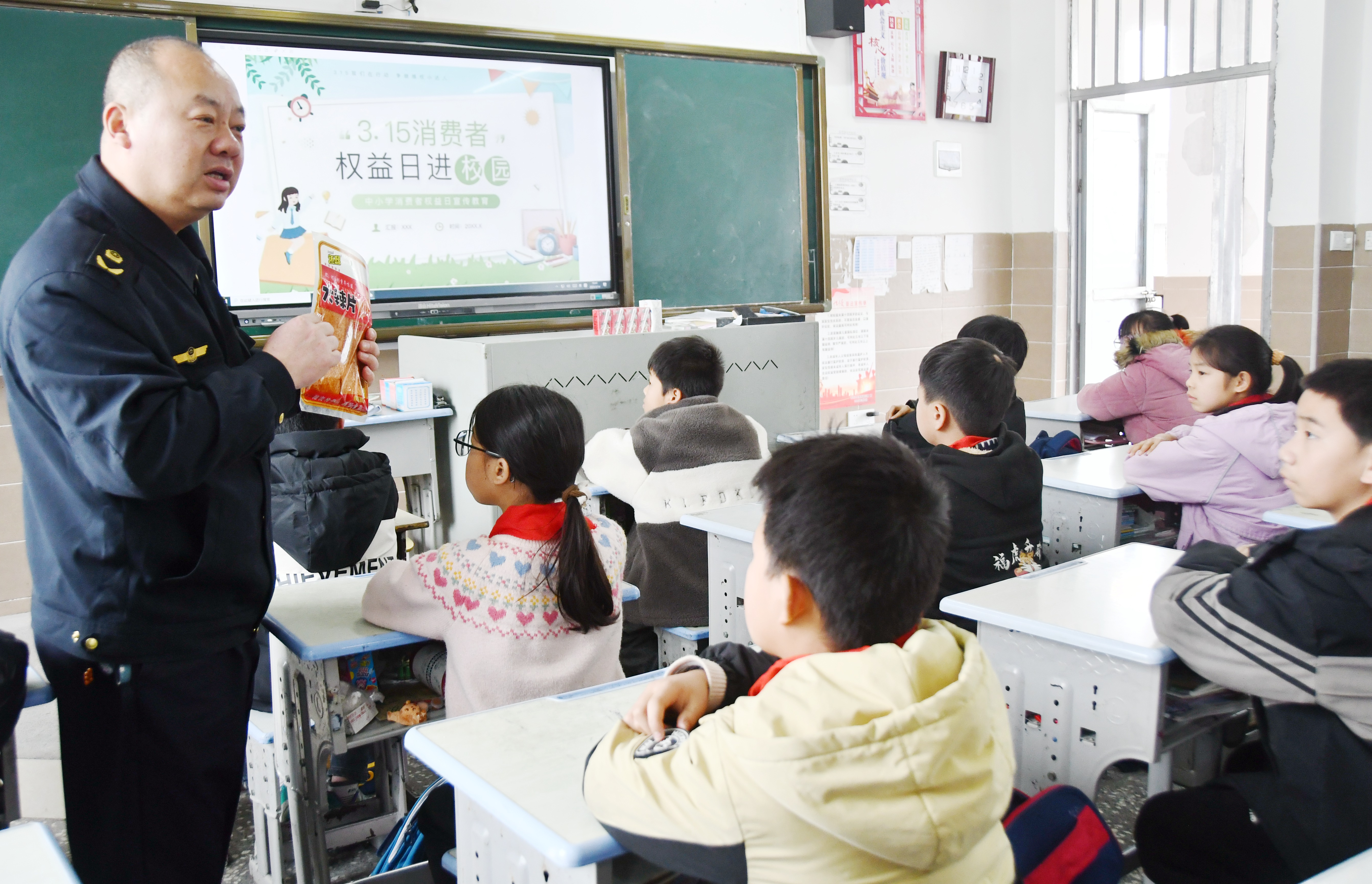 3月14日，在湖南省永州市江永县上江圩镇中心小学，市场监督管理人员正在向学生宣传食品保质期的认识方法。田如瑞摄 (7).JPG