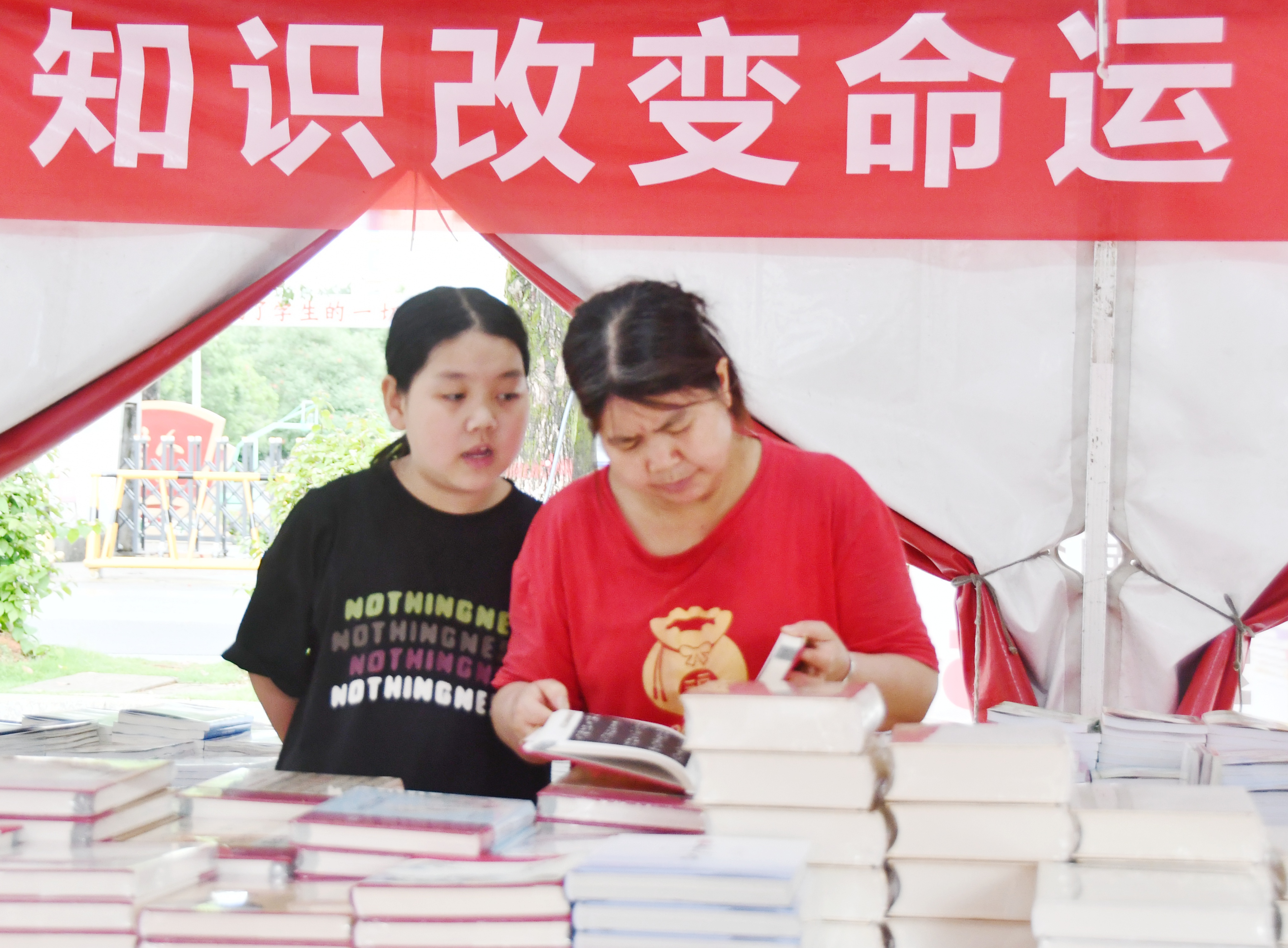 5月18日，在湖南省永州市江永县知青广场图书巡展现场，中学生和家长在选购图书。田如瑞摄03.JPG