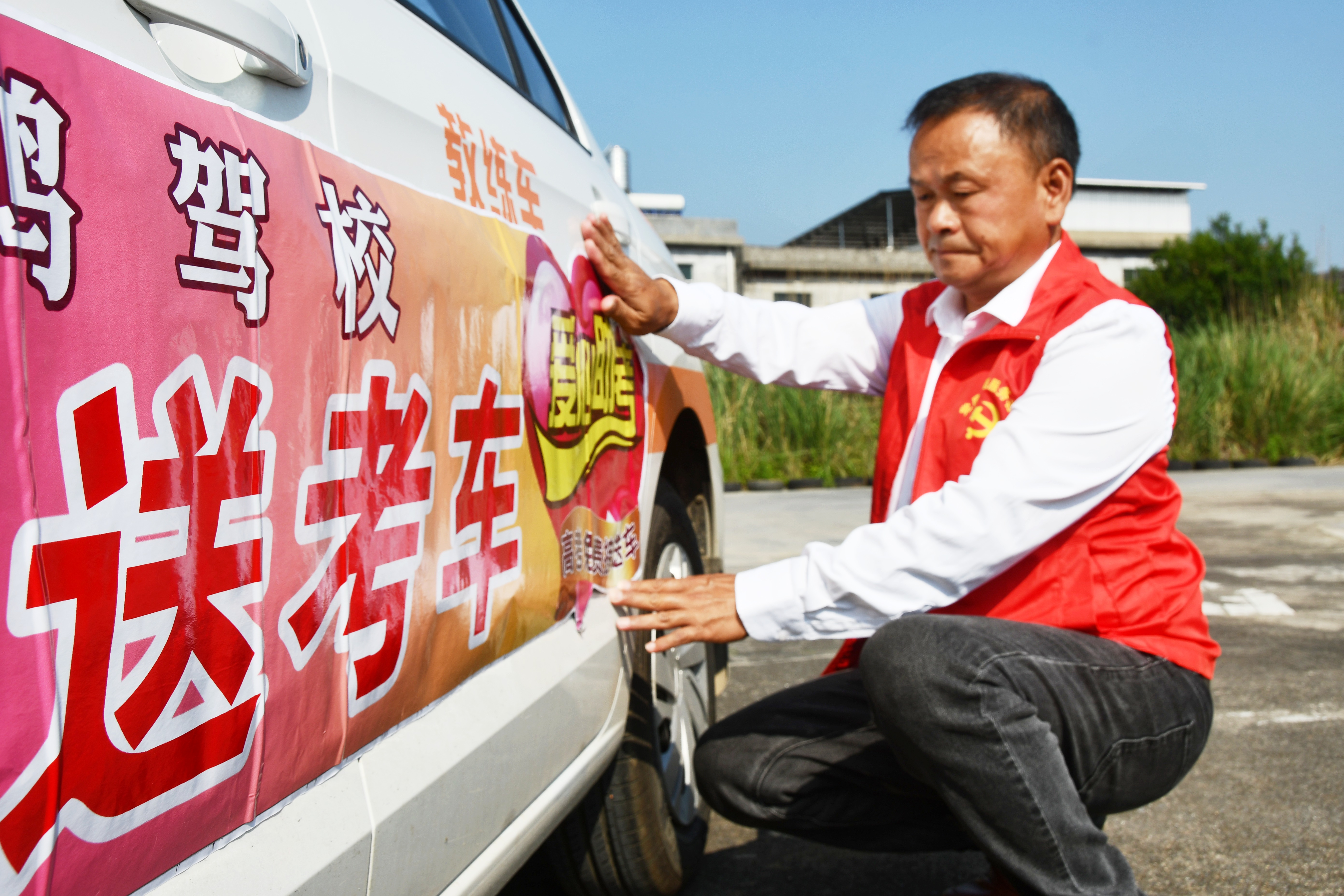 6月4日，湖南省永州市江永县一名志愿者为教练车张贴爱心送考标识。田如瑞摄 2 (1).JPG