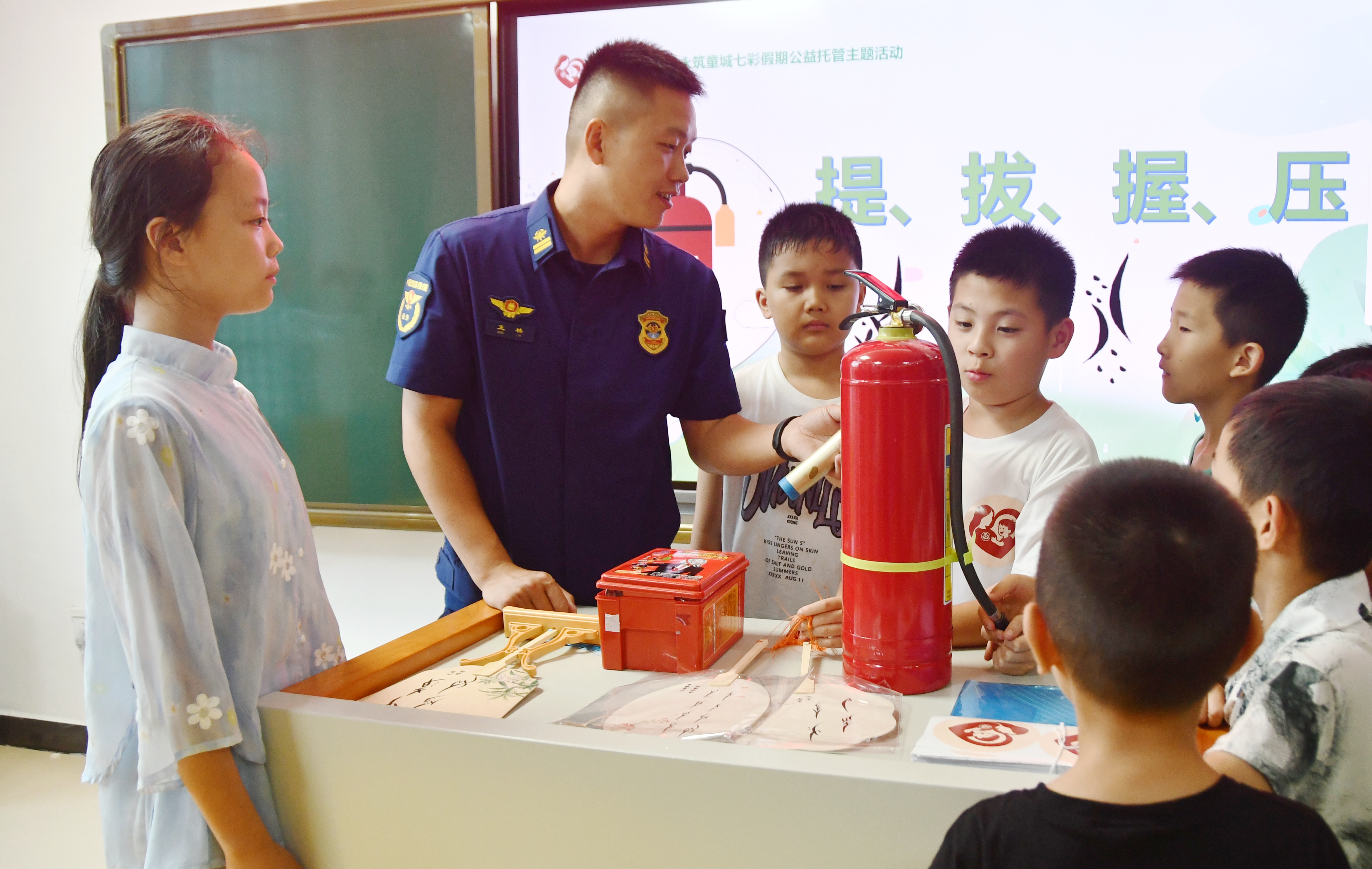 7月14日，湖南省永州市江永县潇浦镇永新社区爱心暑托班，消防救援队员向学生讲解灭火器使用方法。摄1.JPG