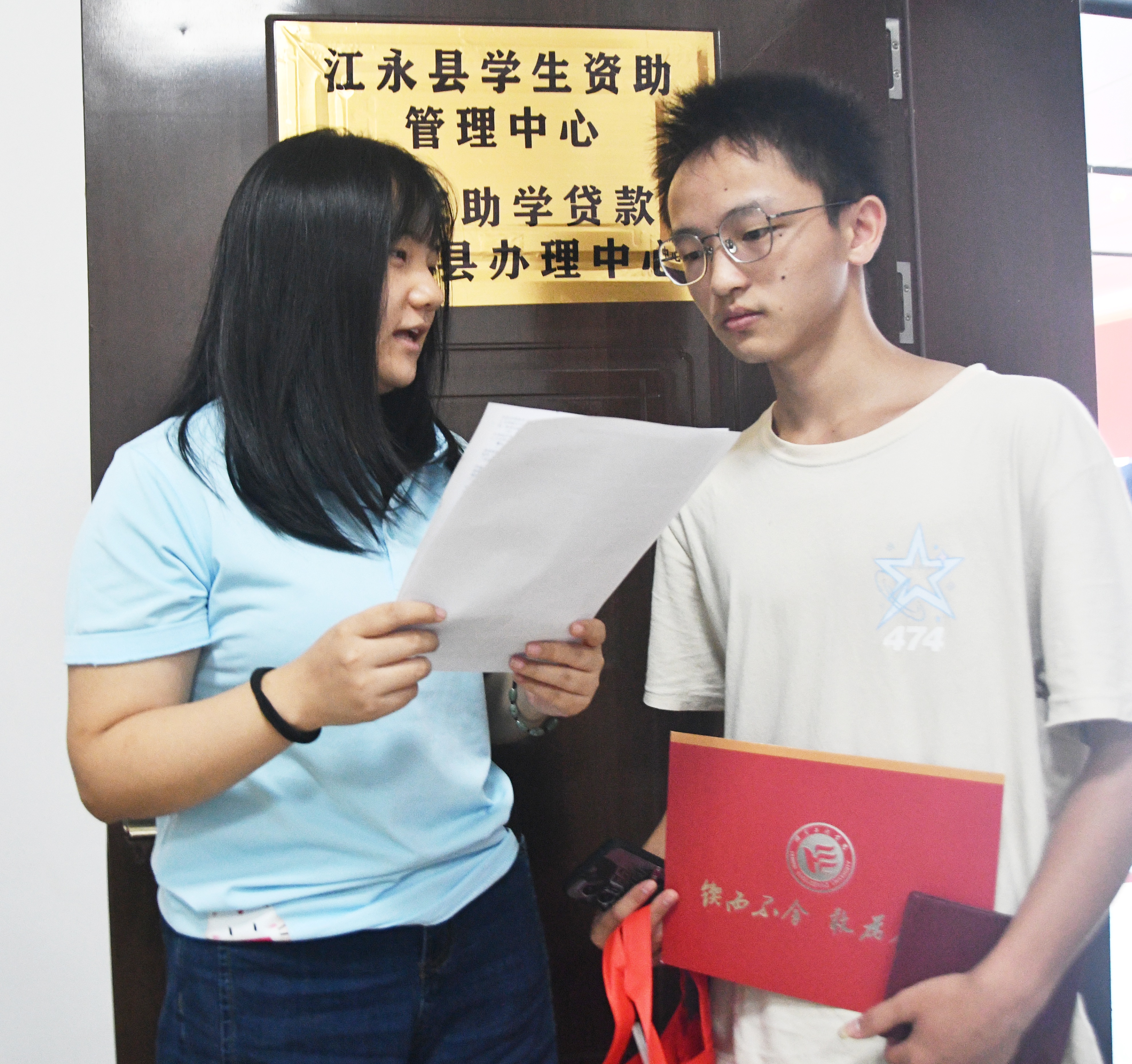 8月12日，湖南省永州市江永县学生资助管理中心，志愿者在为大学新生宣传生源地信用助学贷款政策。(田如瑞）.JPG