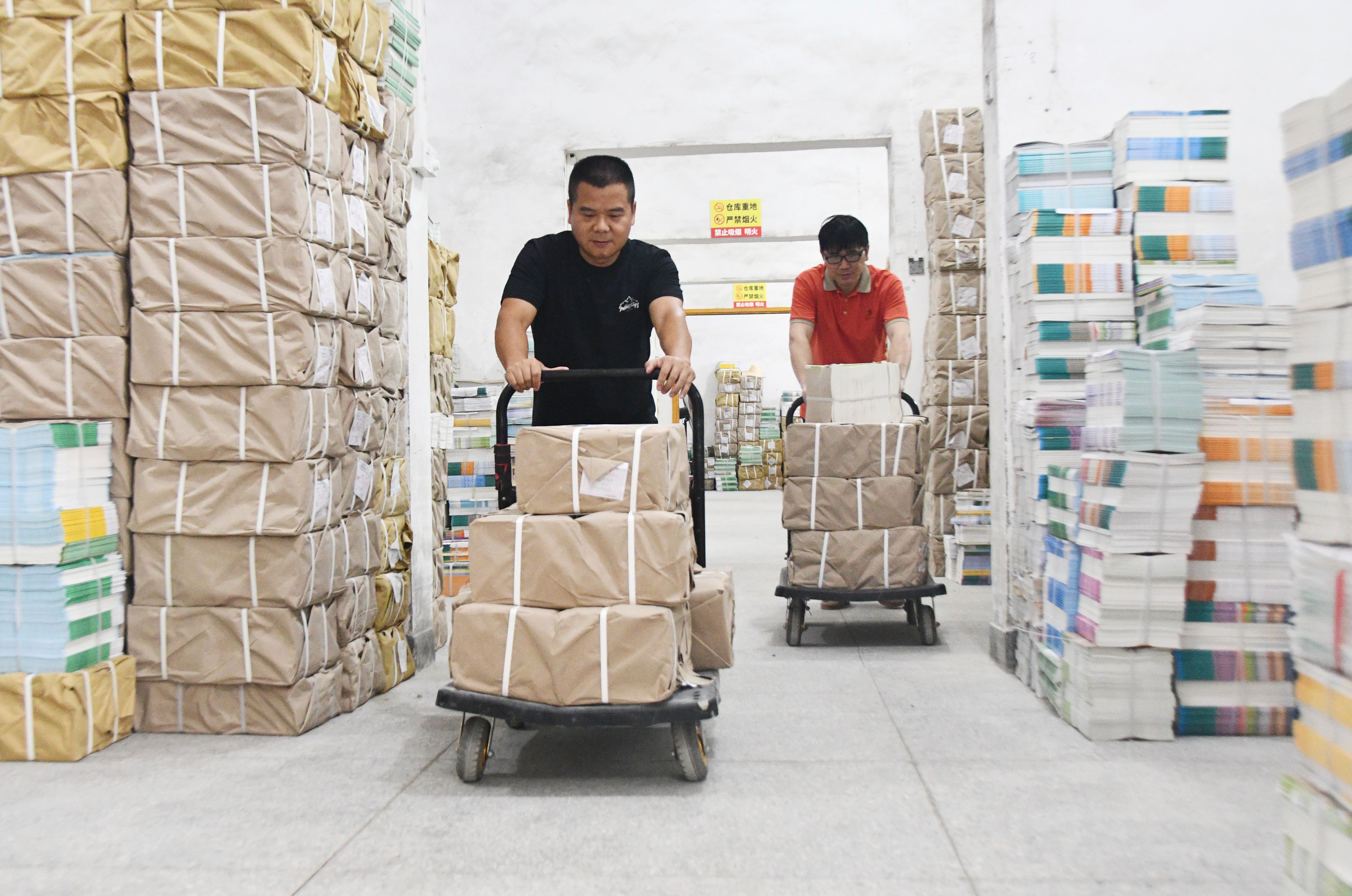 8月21日,工作人员在湖南省永州市江永县新华书店教材仓库内搬运新学期教材。田如瑞摄 (2).JPG