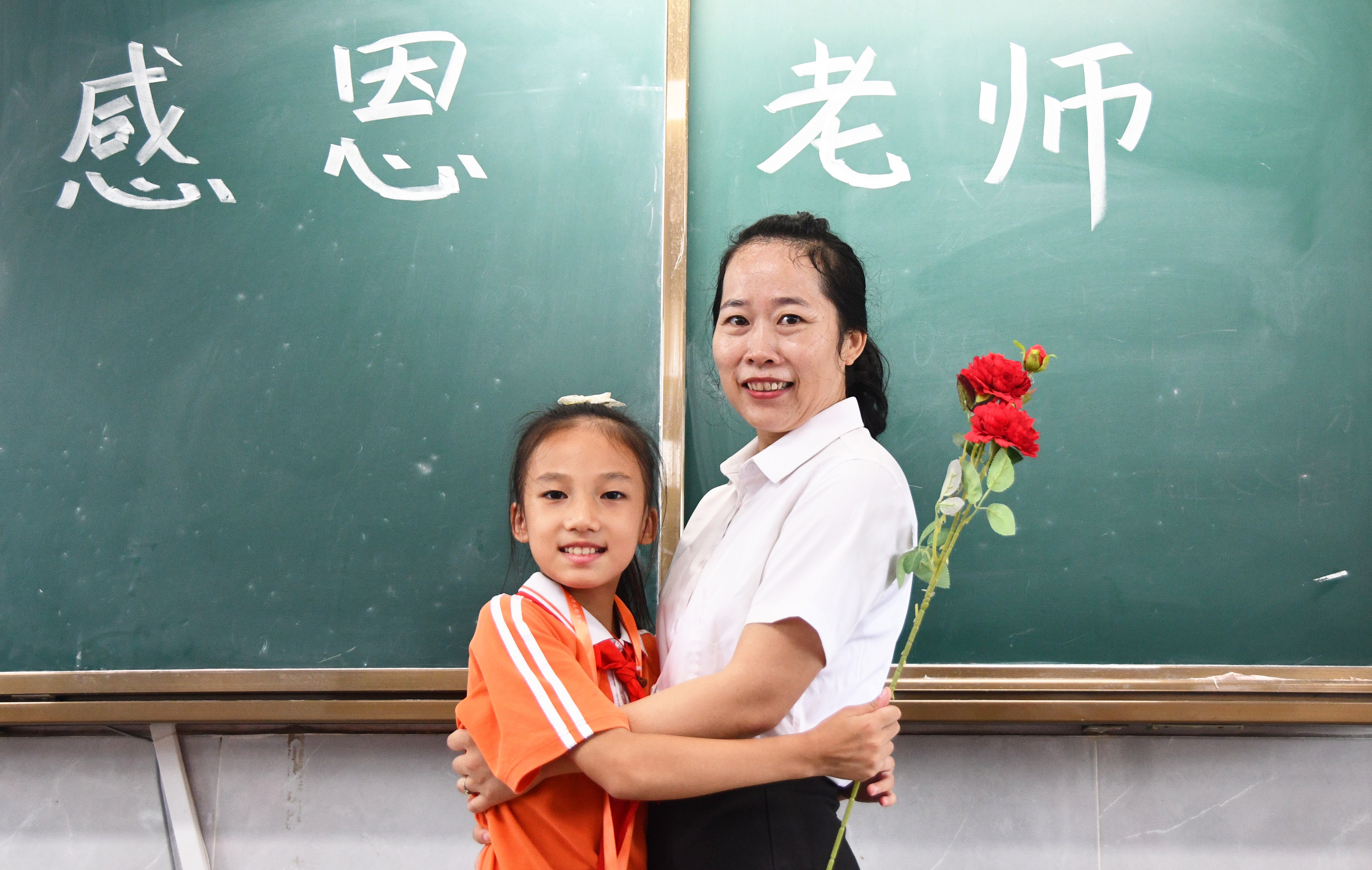 9月9日，湖南省永州市江永县思源实验学校学生向老师送上鲜花，老师拥抱学生表示感谢。田如瑞摄.JPG