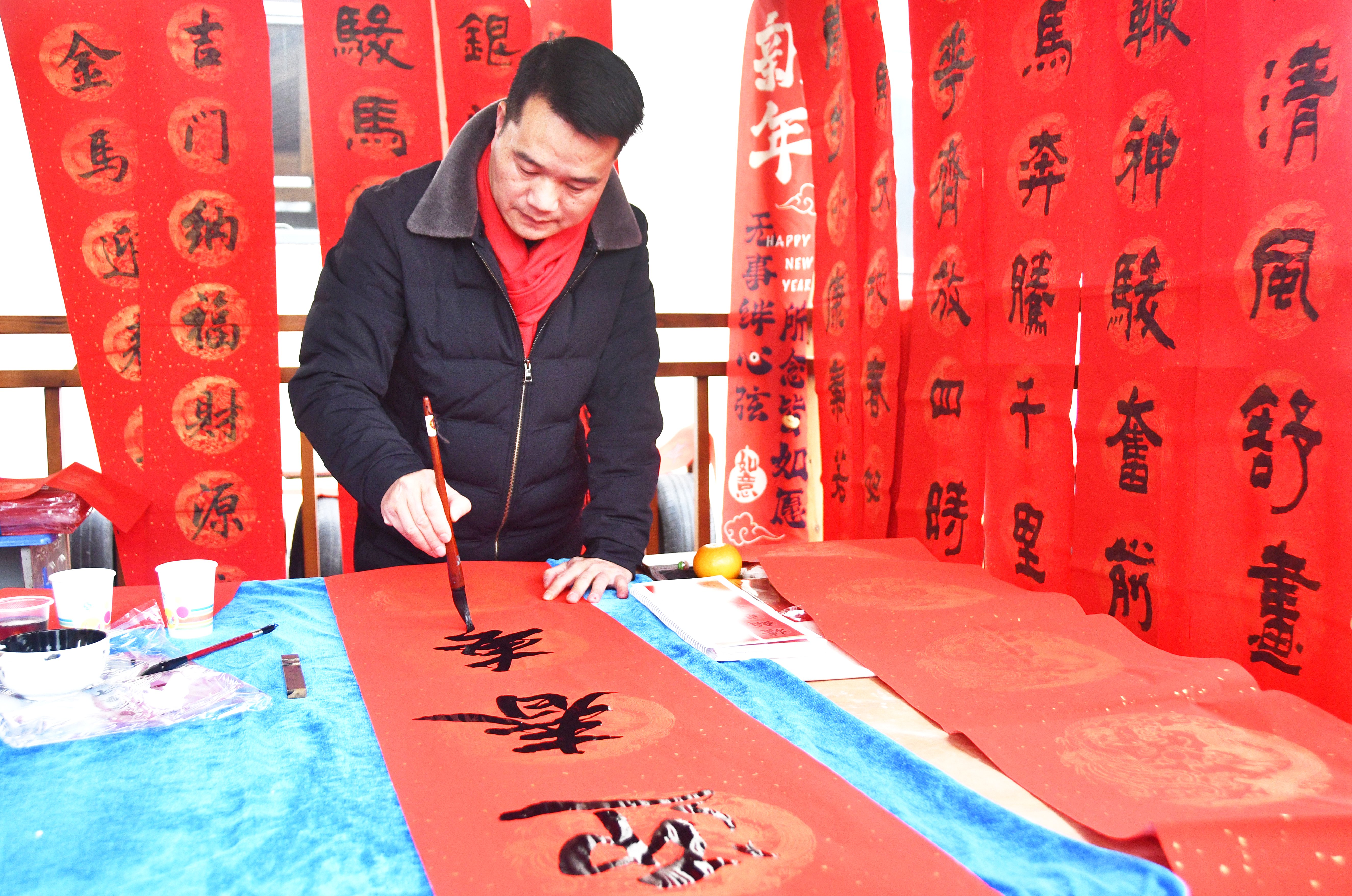 1月26日，书法志愿者在湖南省永州市江永县潇浦镇工业园村为村民写春联。田如瑞摄  (3).JPG