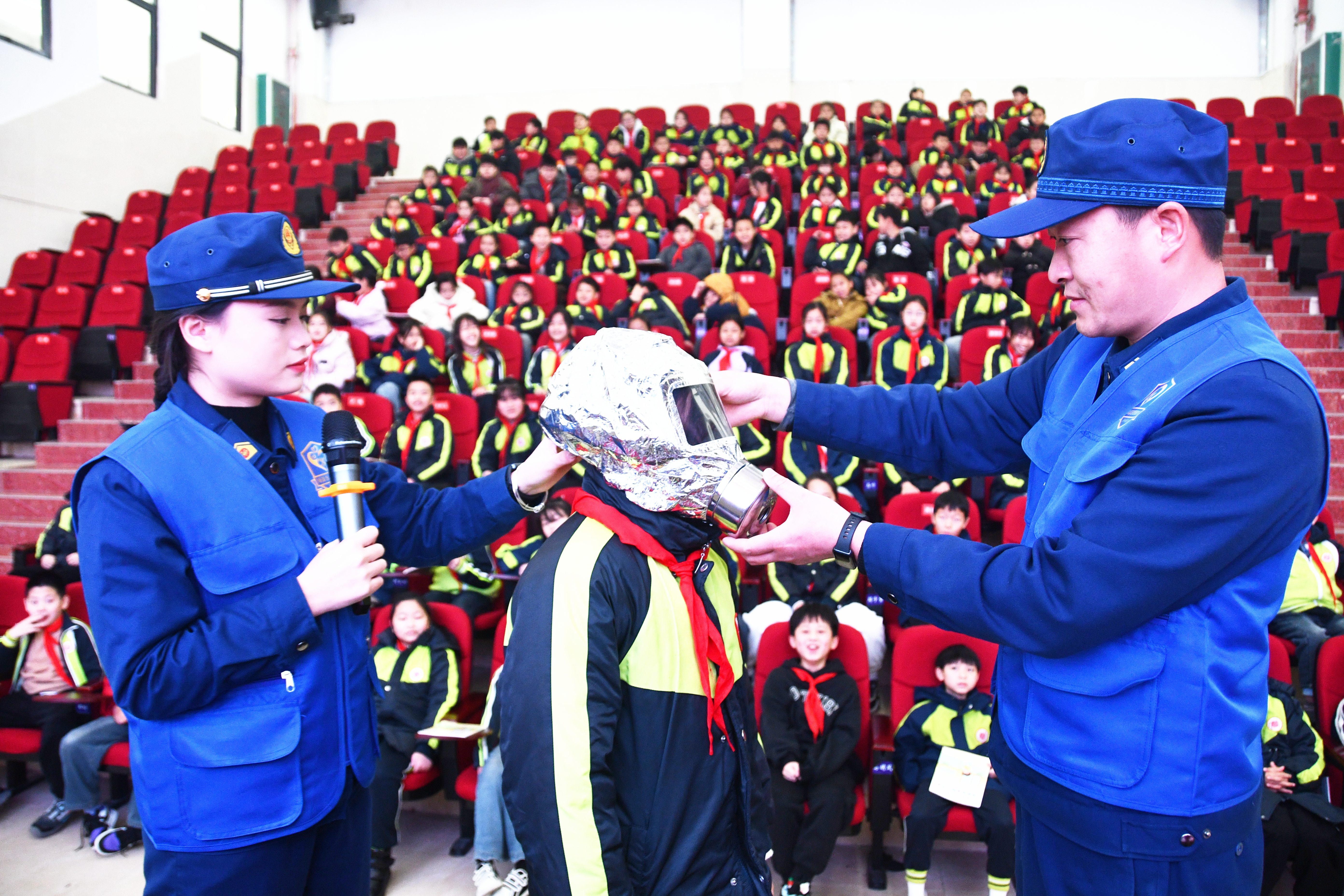 3月4日，湖南省永州市江永县潇浦镇芙蓉学校，小学生在消防救援人员的帮助下体验穿戴消防防护装备。田如瑞摄 (1).JPG