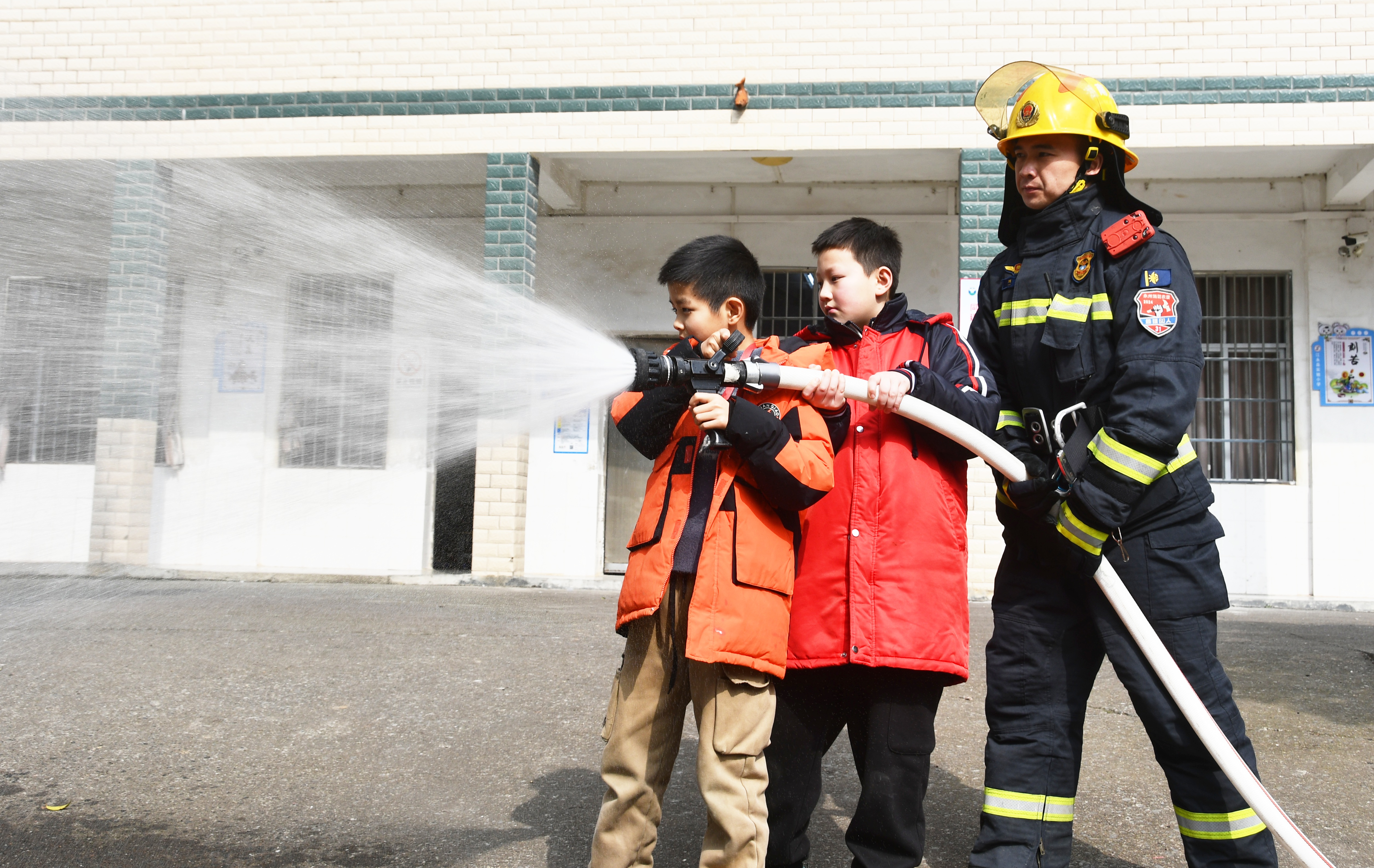 3月5日，湖南省永州市江永县实验小学学生在消防救援人员的帮助下体验灭火水枪的使用。田如瑞 (3).JPG