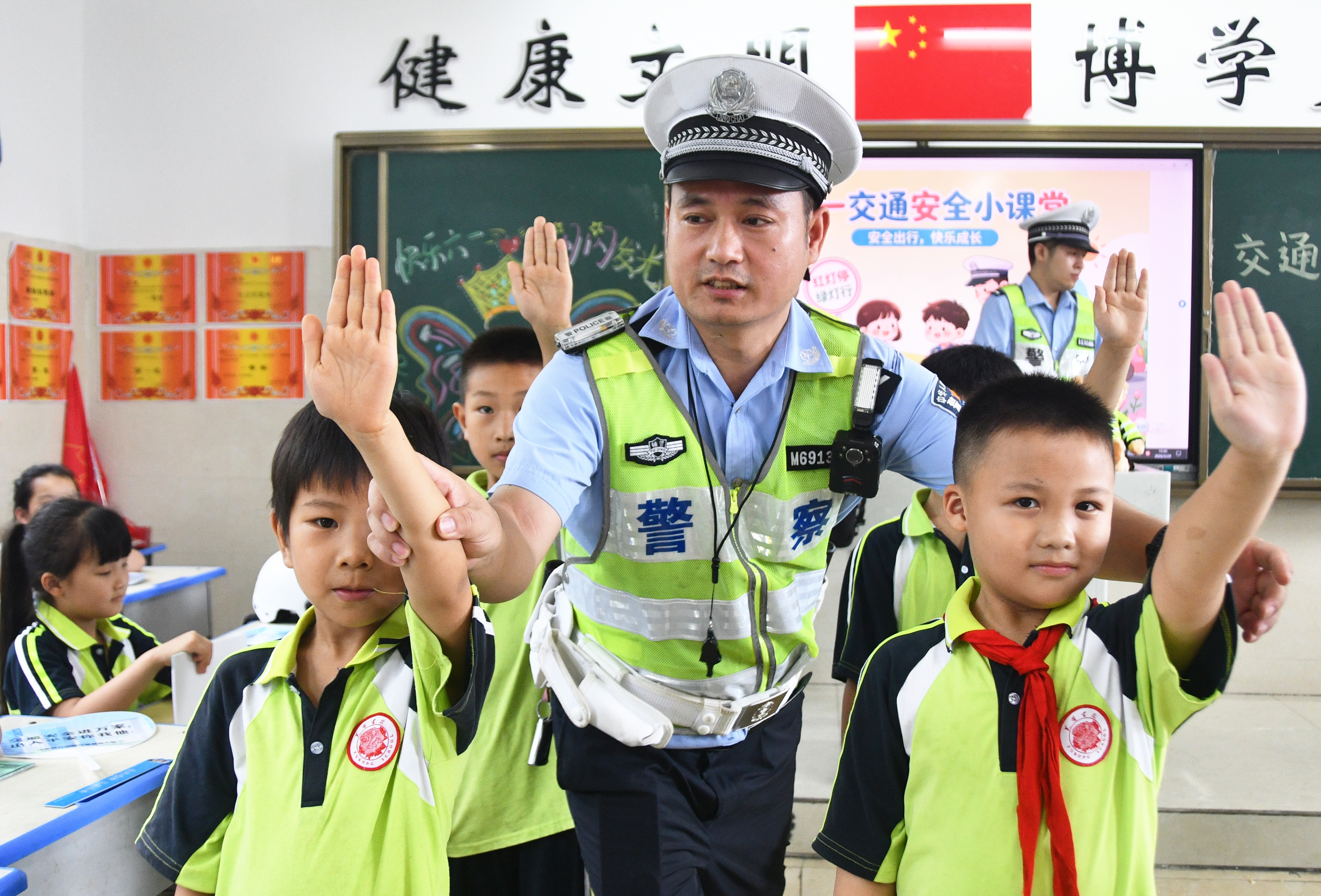 5月29日，在湖南省永州市江永县潇浦镇芙蓉学校，交警向小学生演示交通指挥手势。田如瑞摄 (2).JPG