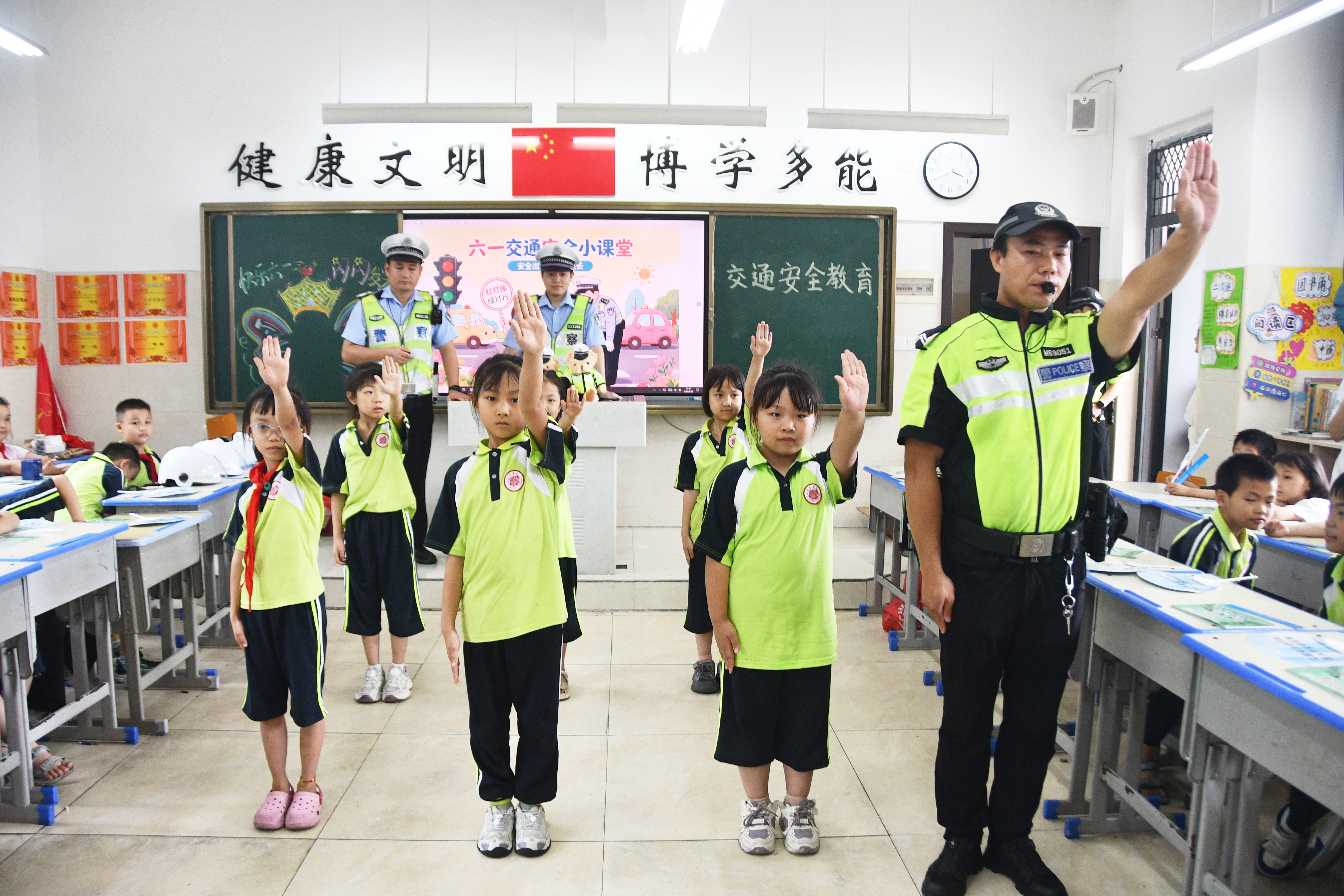 5月29日，在湖南省永州市江永县潇浦镇芙蓉学校，交警向小学生演示交通指挥手势。田如瑞摄 (1).JPG