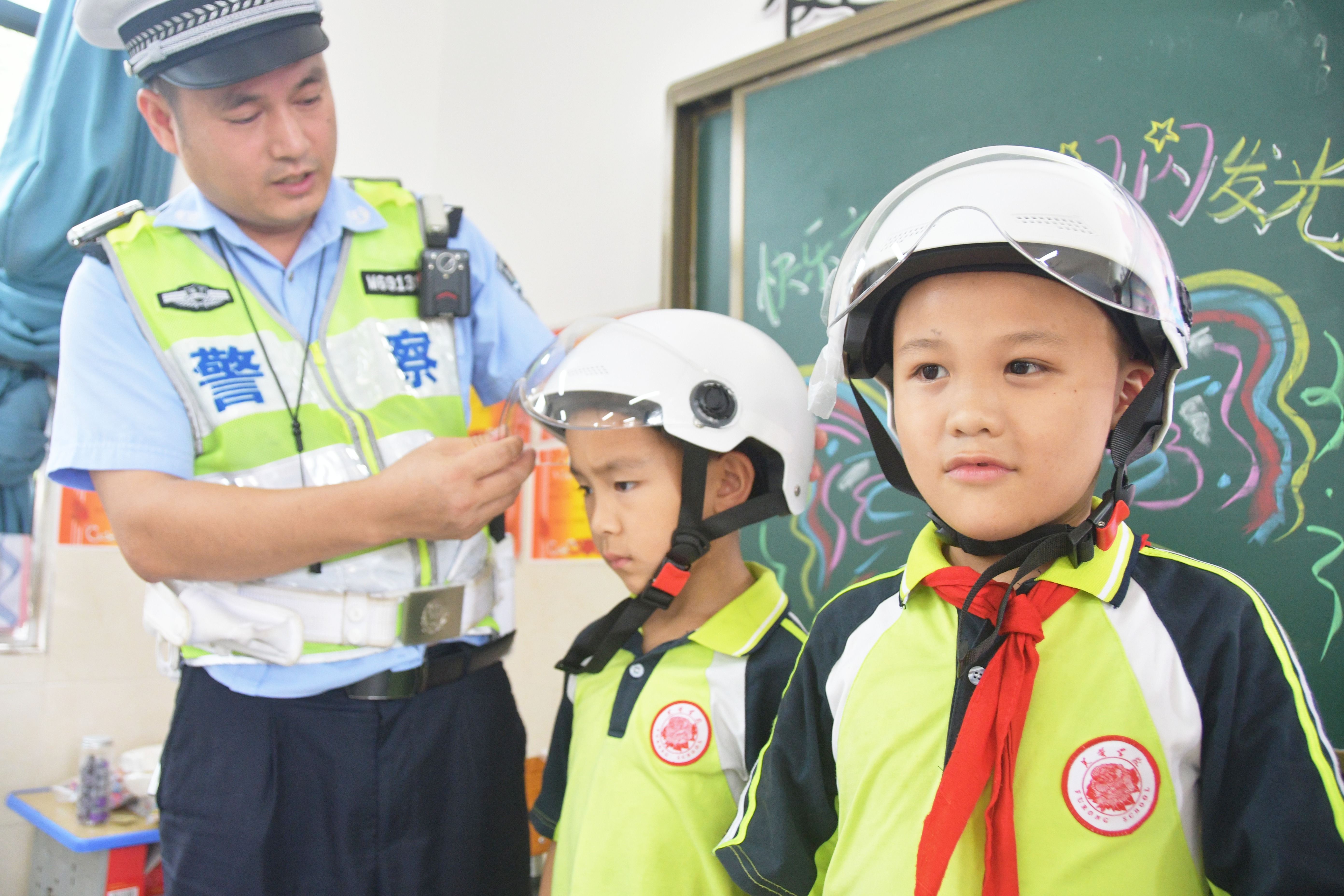 5月29日，在湖南省永州市江永县潇浦镇芙蓉学校，交警教学生如何正确佩戴头盔。田如瑞摄.JPG