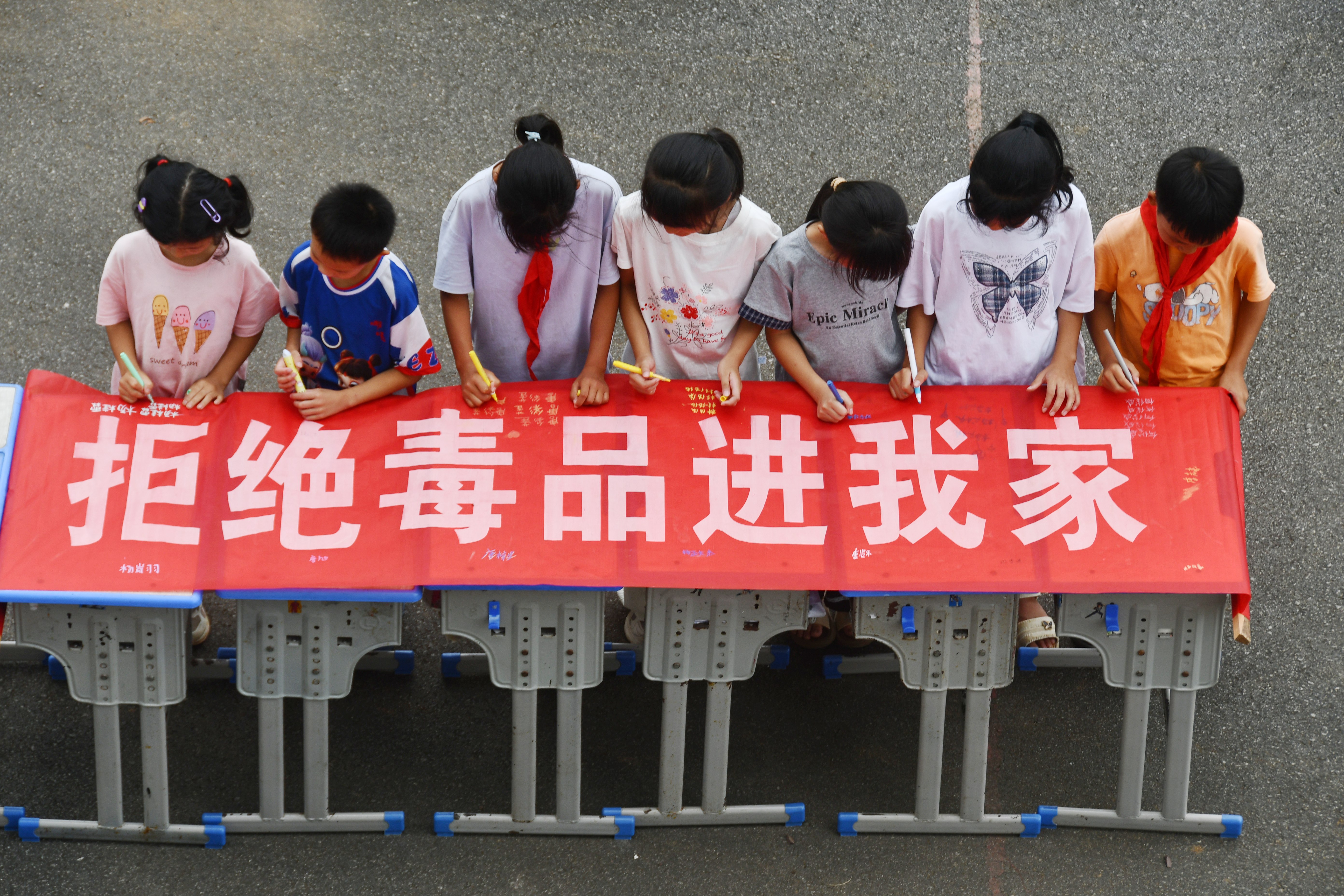6月26日，湖南省永州市江永县海相希望小学，学生在“拒绝毒品进我家”横幅上签名。田如瑞摄.JPG