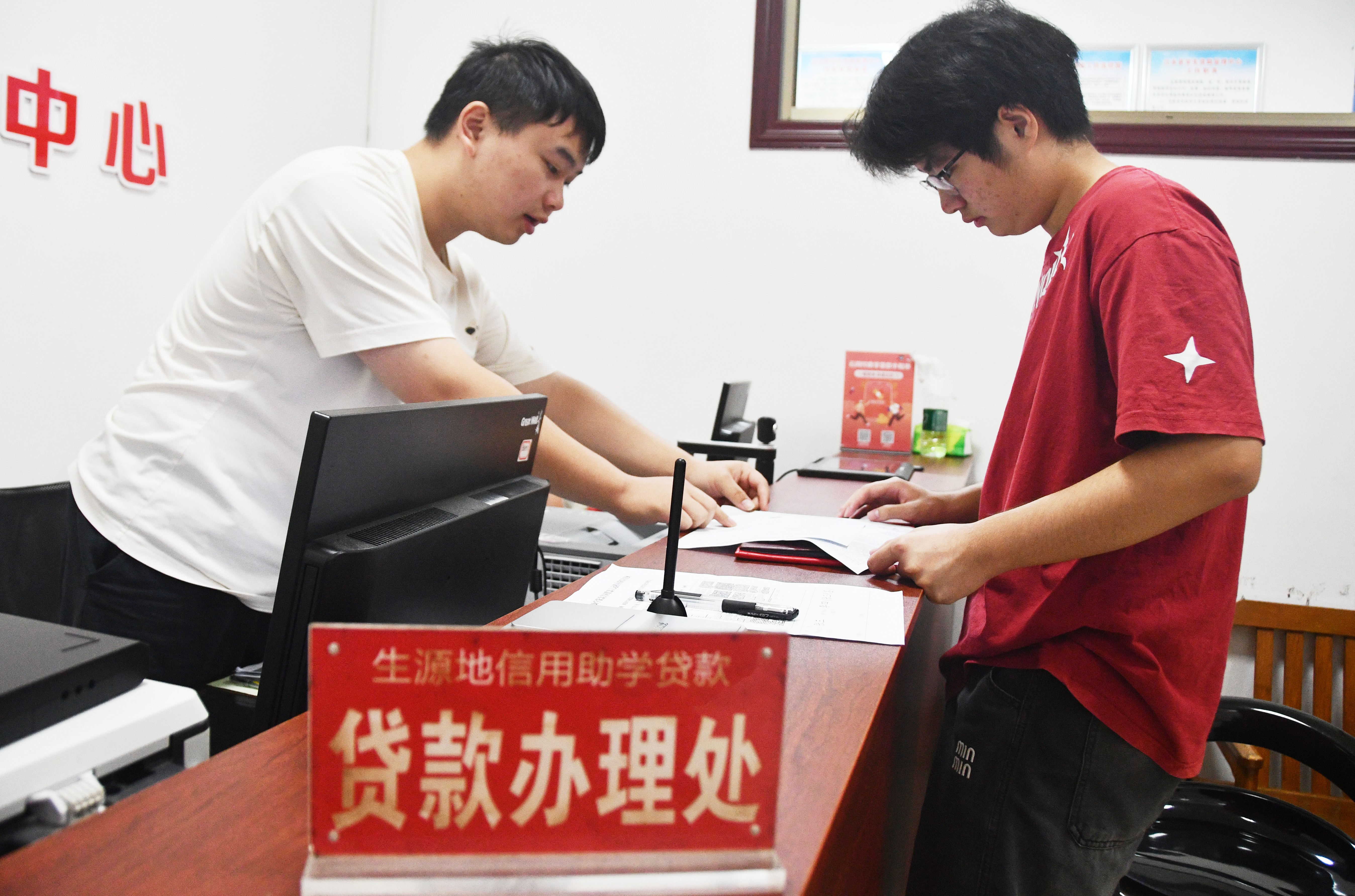 8月13日，在湖南省永州市江永县国家生源地信用助学贷款办理中心，大学新生在家长的陪同下前来办理生源地信用助学贷款业务。田如瑞摄 (10).JPG