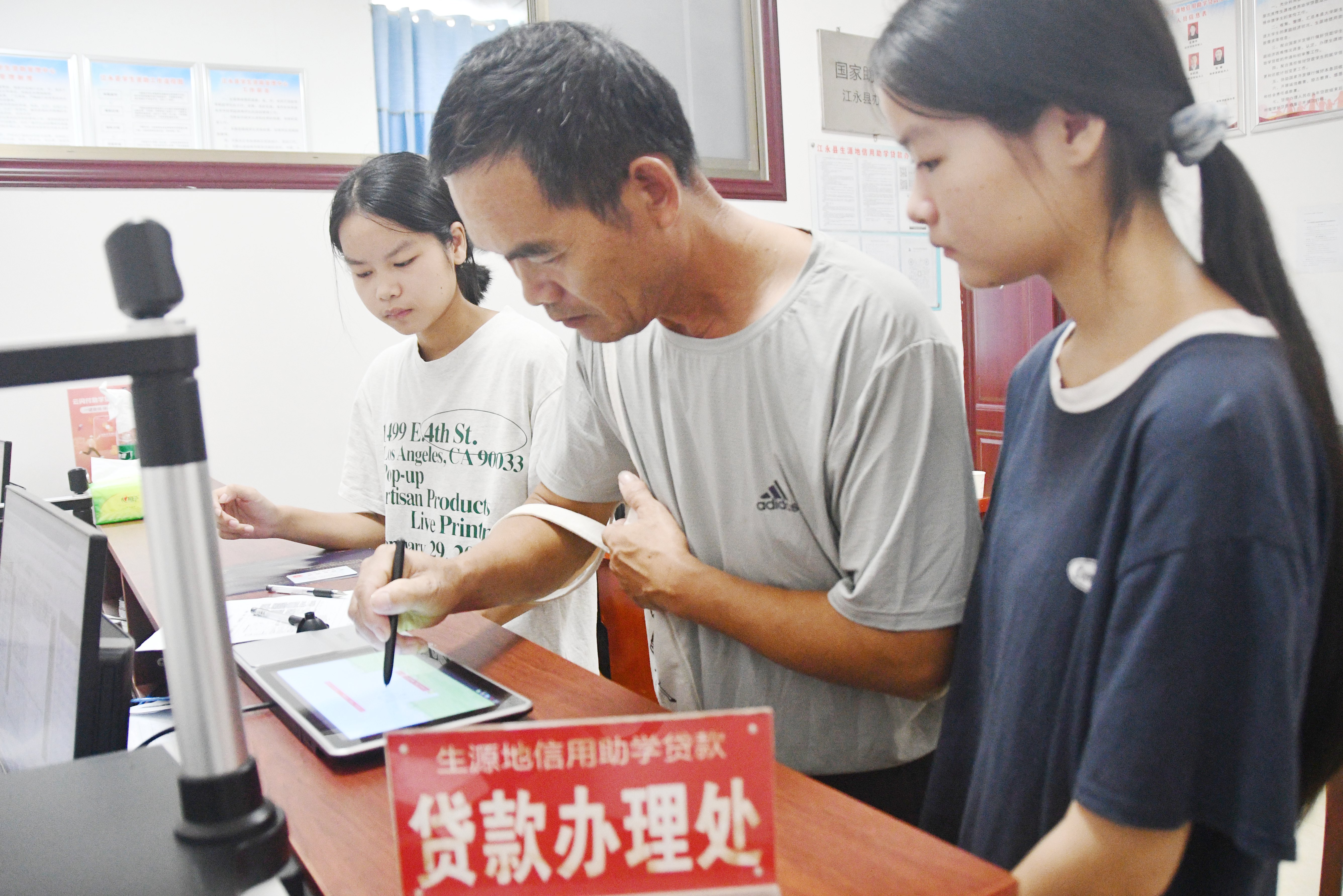 8月13日，在湖南省永州市江永县国家生源地信用助学贷款办理中心，大学新生在家长的陪同下前来办理生源地信用助学贷款业务。田如瑞摄 (6).JPG