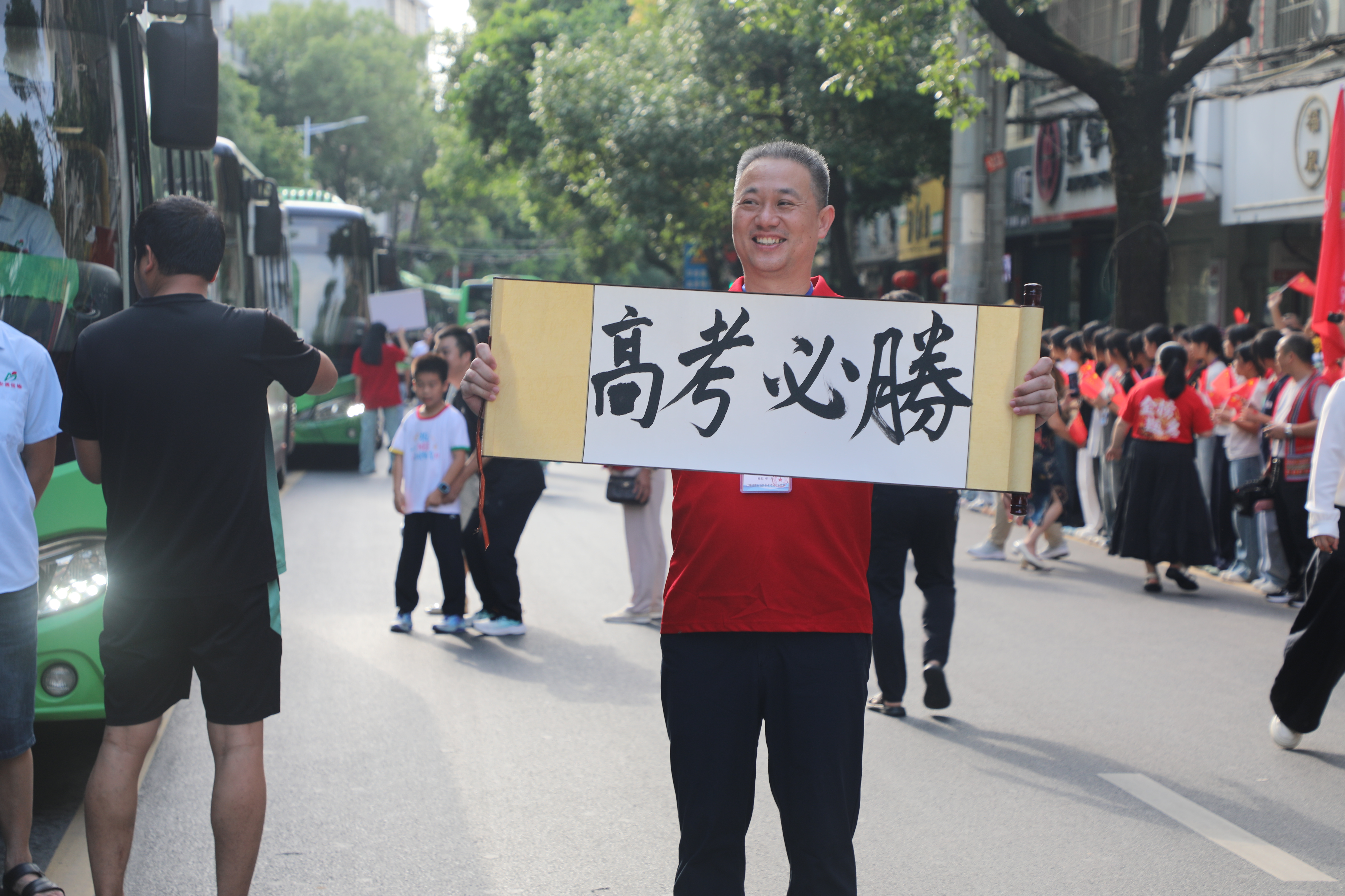 高考首日，江华二中考点送考老师举着“高考必胜”的书法作品送考。唐世日摄.JPG