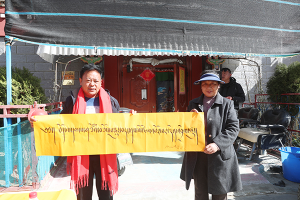 图为书法家和群众合影 写着庆祝西藏民主改革65周年。.jpg