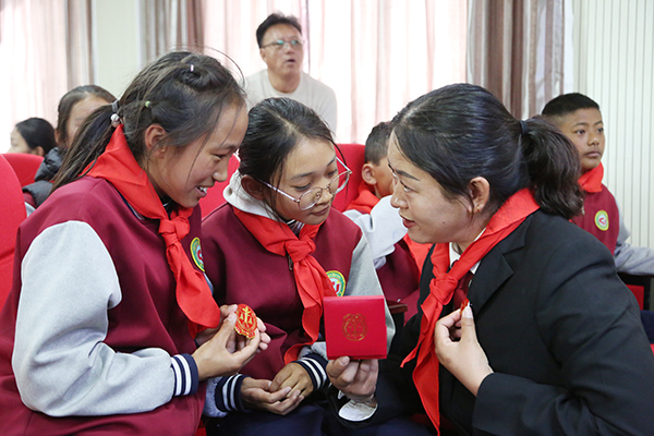 图为单增卓嘎正在为学生们展示和讲解庄严的法徽.JPG