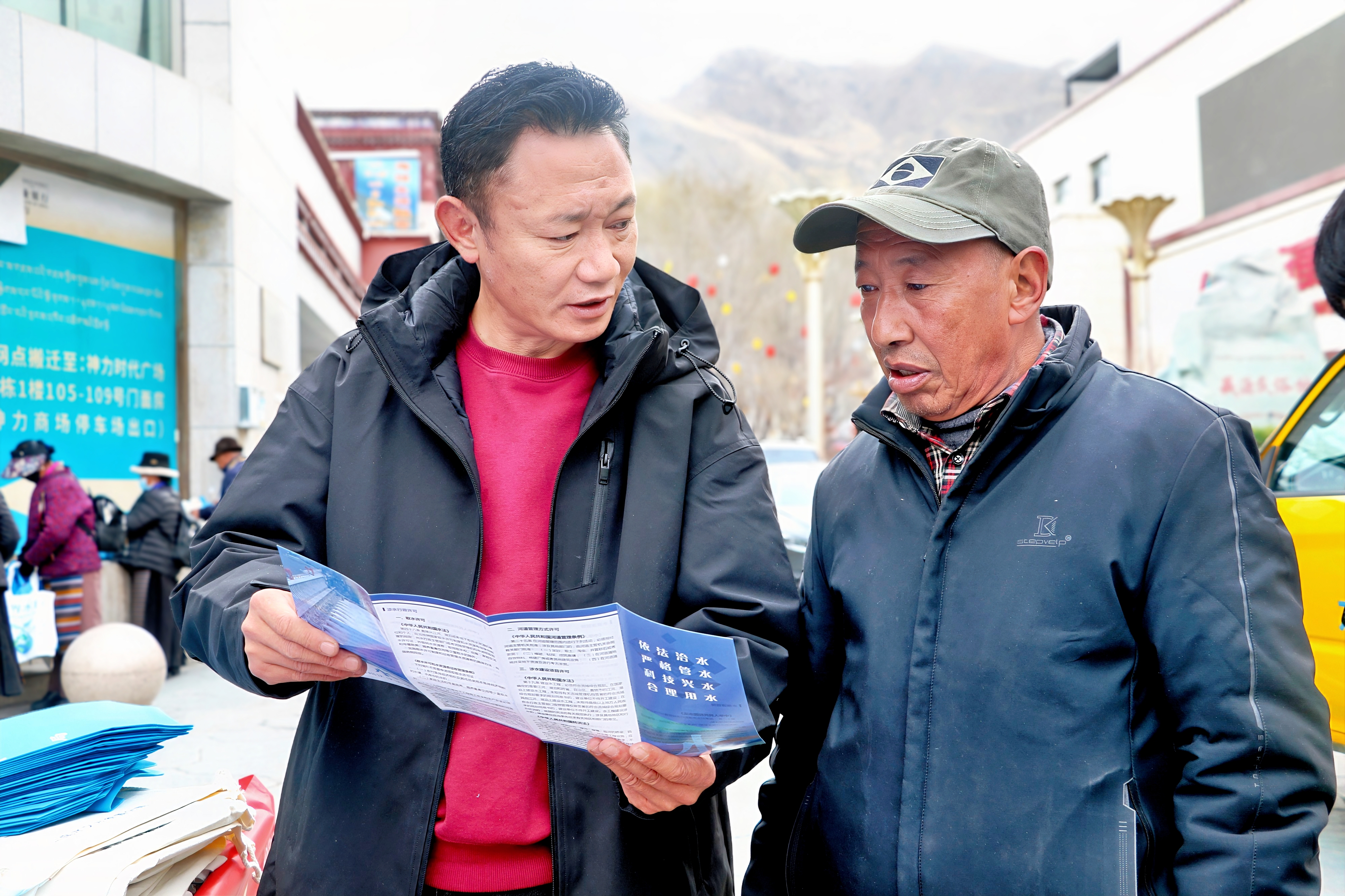 图为宣传活动现场，工作人员为过往市民群众发放宣传手册、详细普及日常生活中节约用水小技巧。 (3).jpg