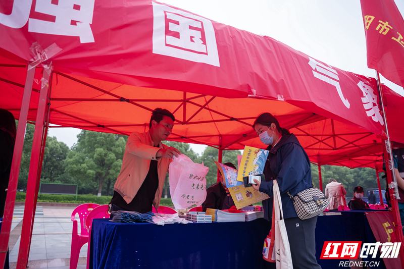 气象局工作人员向群众赠送气象防灾减灾知识册。