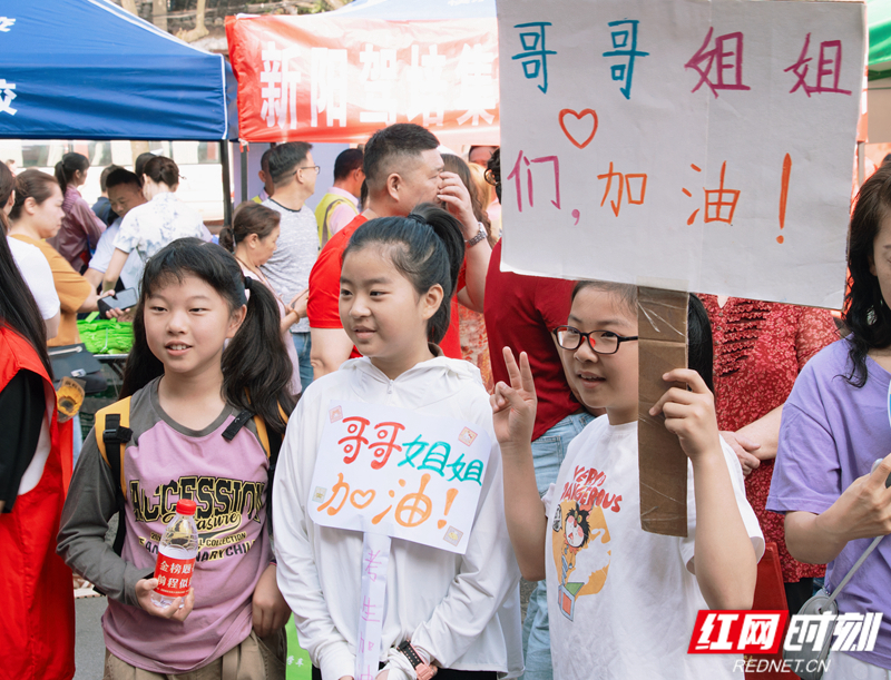 在岳阳市第一中学考点外，小朋友们为哥哥姐姐加油助威。