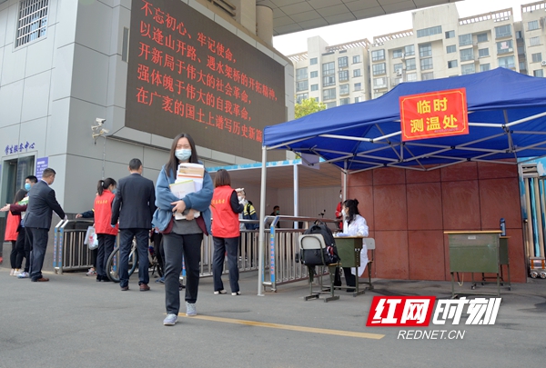 4月7日，根据统一安排，常德的高三初三学生们陆续踏入校园，迎来了复学第一课。“你好，同学！”成为了学校欢迎学生们最动听的声音，测体温、戴口罩、分餐制……一切学习从做好疫情防控工作开始。图为芷兰实验学校学生经过体温测量消毒后，抱着书本进入校园。