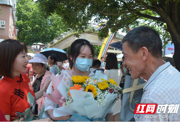 直击高考首日丨语文考试结束 家长抱鲜花在场外等候