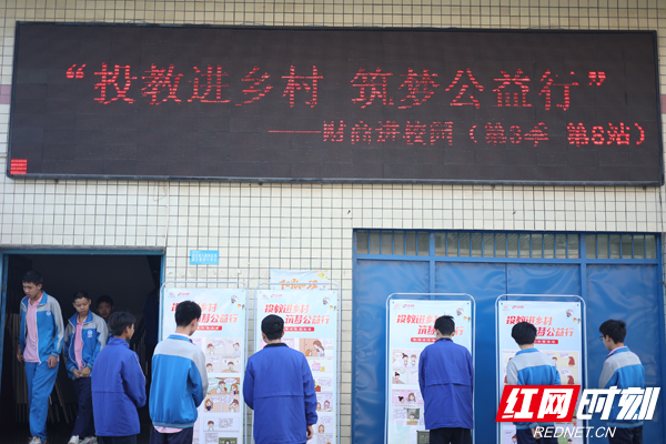 课后，学生们认真学习易拉宝上的金融知识。