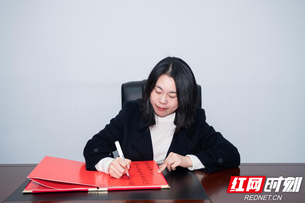 浏阳市财信融资担保有限责任公司董事长王莹接受红网时刻新闻记者采访，她表示，“作为县域金融机构，浏阳财信融担始终坚持‘深耕本土、支小支新’的市场定位，通过特色化、专业化，全覆盖、接地气的金融服务，源源不断将金融活水引向县域，助力县域新兴产业向新向强。”图为她为活动书写寄语。