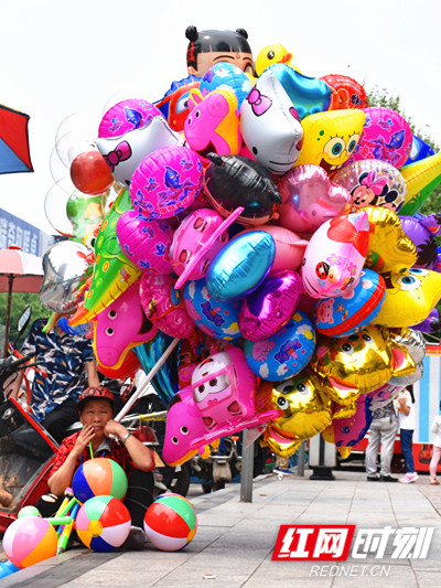 街头卖氢气球的小贩。（李梅花/摄）