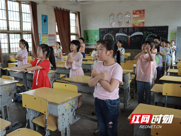图为舞蹈课上志愿者教小朋友们做手语操——听我说谢谢你。