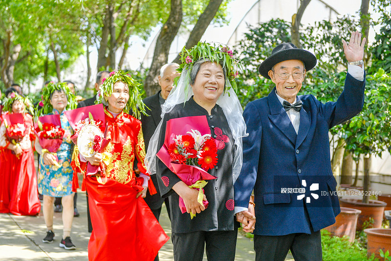 2020年5月19日，浙江湖州长兴县夹浦镇长平村生态园，袁宝金（右一）、付巧凤金婚夫妇穿越爱情长廊时开心挥手。