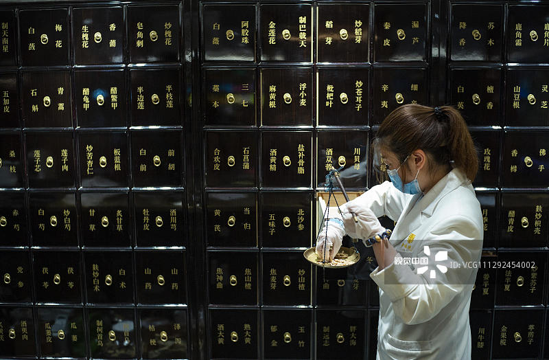 2020年7月22日，位于北京市朝阳区双井附近的一家“同仁堂知嘛健康”店内，一名工作人员在抓取药材。据悉，这是北京老字号同仁堂旗下新零售板块，店内除传统的问诊抓药外，还出售咖啡、面包，也可用半自助的方式选购健康食材等。