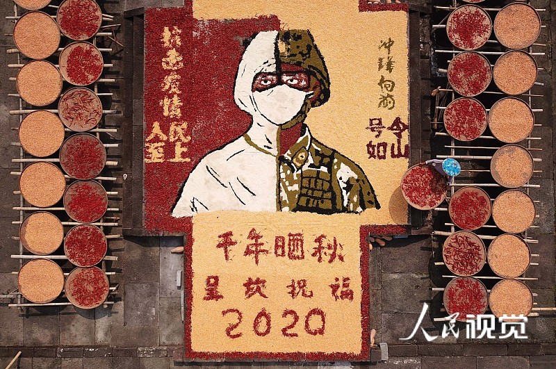 2020年8月27日，安徽省黄山市，呈坎古村村民在晒场上晾晒农作物。
近日，安徽省黄山市呈坎古村村民利用晴好天气，将收获归仓的玉米、黄豆、南瓜和红辣椒等五彩缤纷的果实，因地制宜晾晒在村中晒场，创意地拼出“国泰民安、风调雨顺”字样及战士、医护卡通形象，以农家特有的方式向祖国表达美好祝愿，向“最美逆行者”致敬。